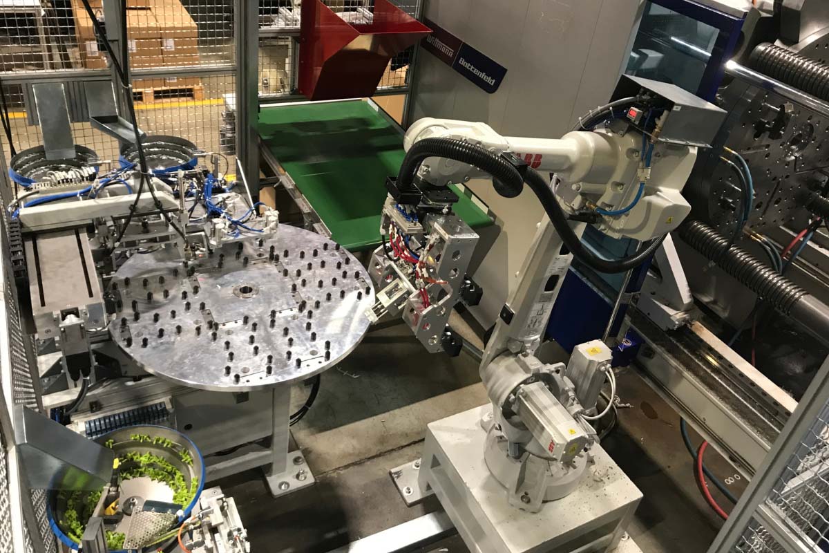Robotska celica za posluževanje stroja za brizganje plastike ter linija za montažo vijakov in gumbov v ohišje
