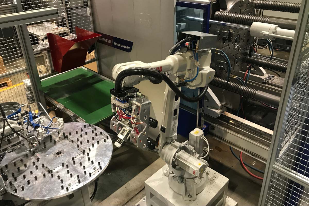 Robotsko posluževanje stroja za brizganje plastike in montaža elementov v plastična ohišja; vstavljanje gumbov ter vijakov